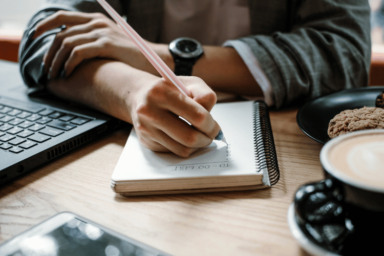 Person Writing To-do List on Notebook